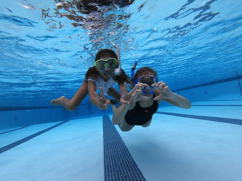 two girls swimming under water