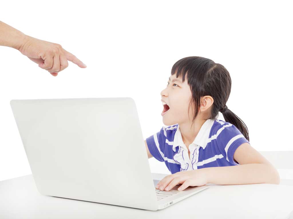 Parent scolding young girl using a laptop.