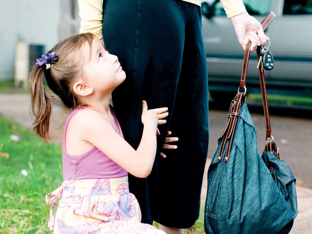 daughter clinging onto mom's leg as she goes to work