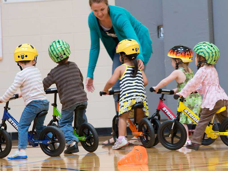 young kids learning how to ride a bicycle