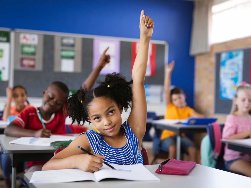 child raising her hand in class