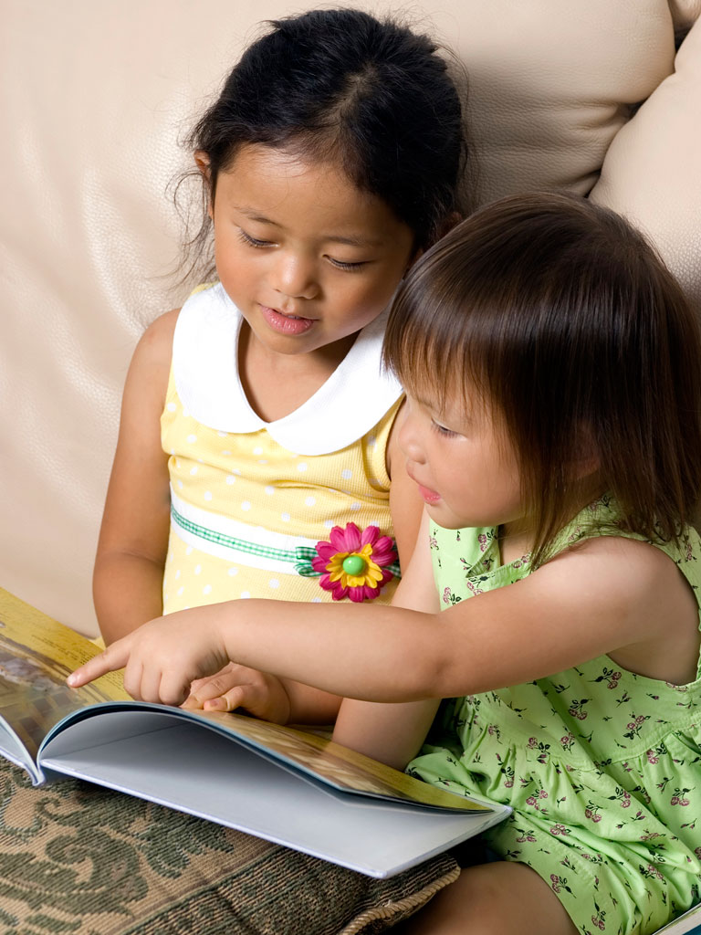 siblings reading a book