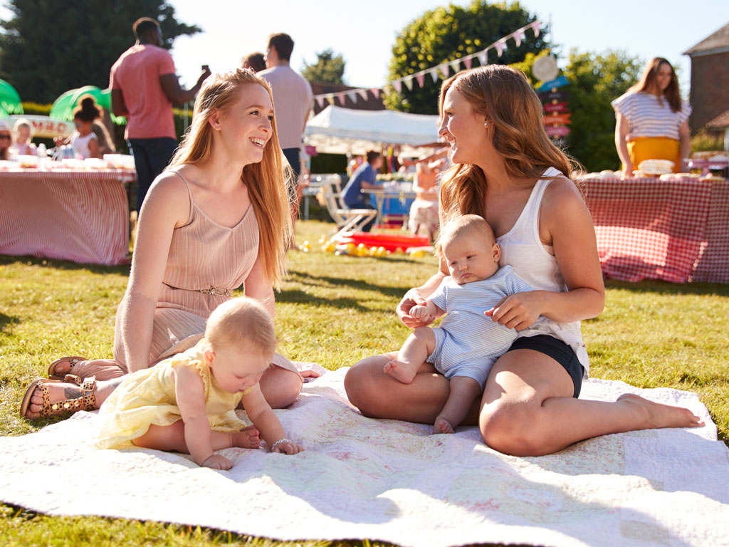 two moms talking and having a picnic with their babies