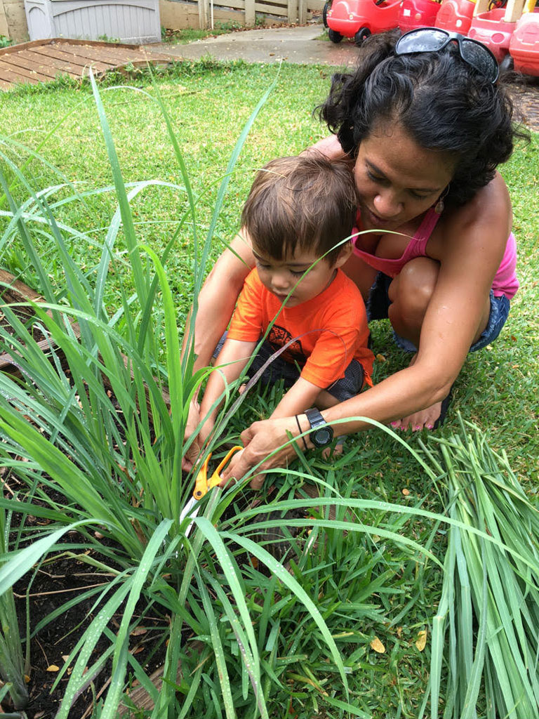 Mother teaching infant son how to garden