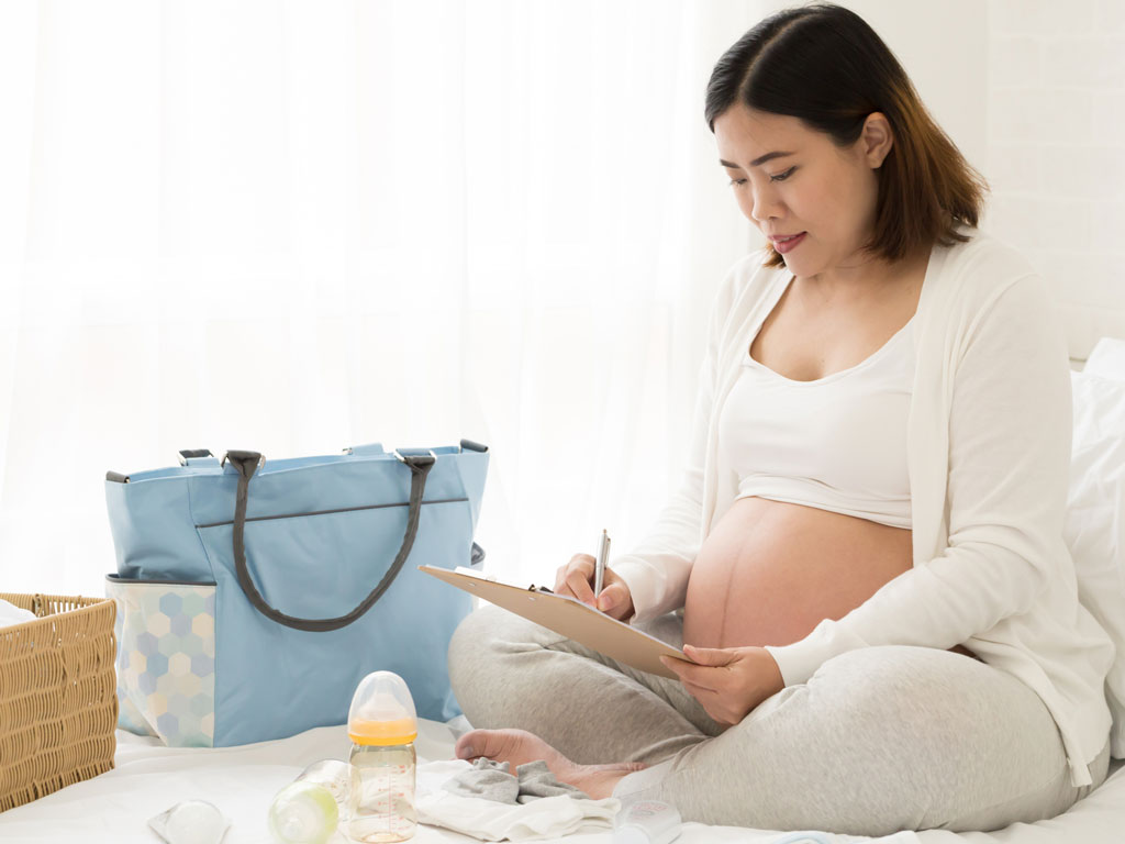 pregnant woman packing a bag in preparation for birth