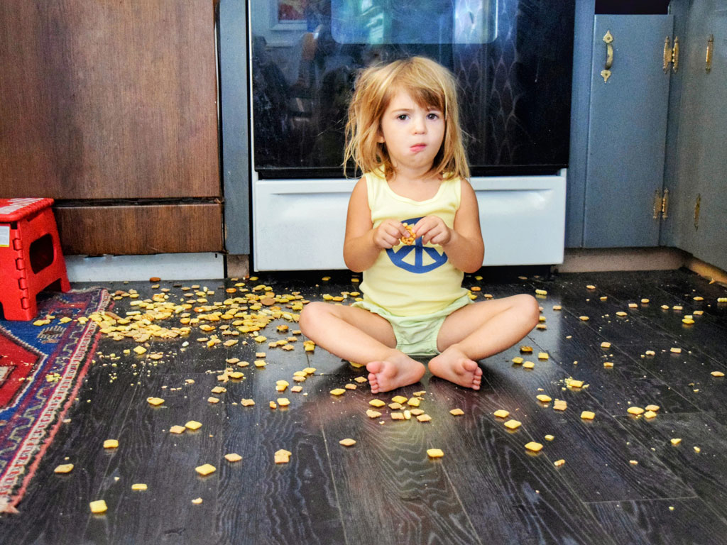 child on the kitchen floor making a mess