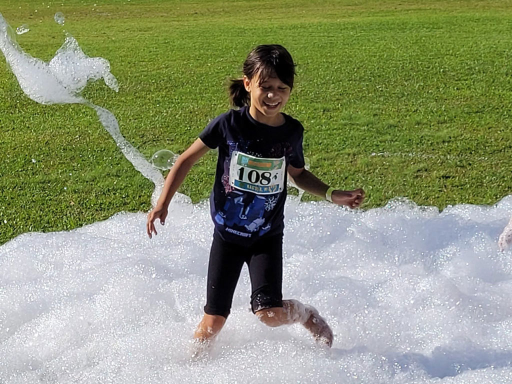 child at keiki great aloha run having fun in bubbles
