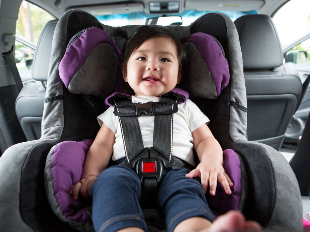 happy baby safely tucked in a car seat