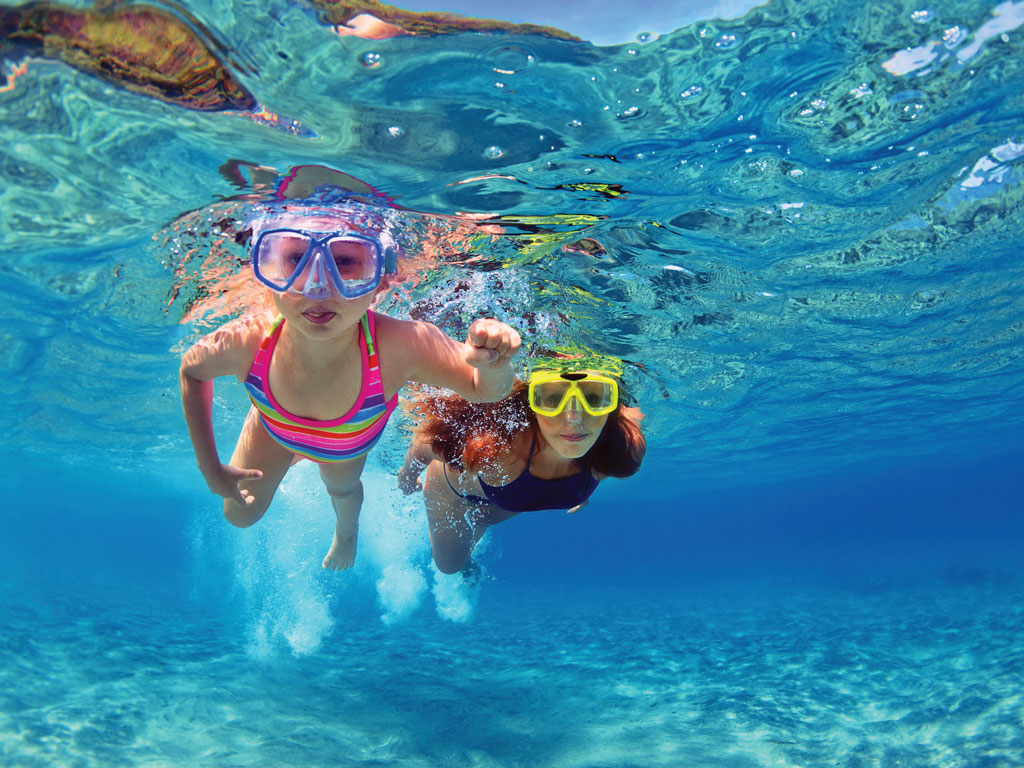 two girls swimming under water