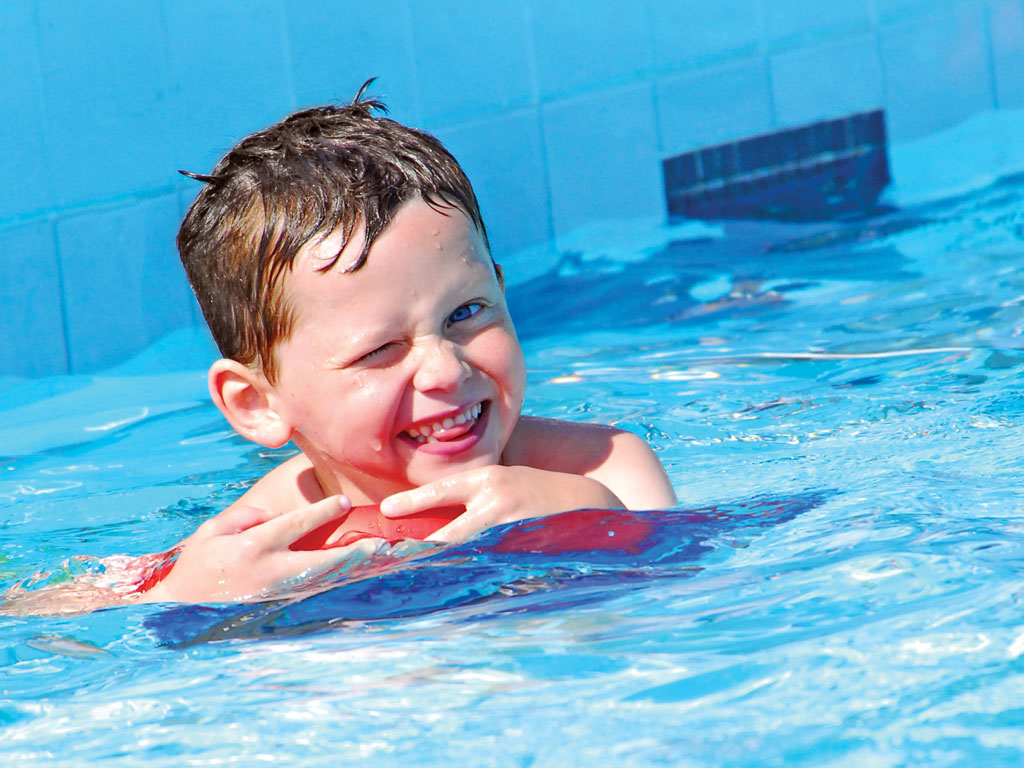 young male child having fun swimming