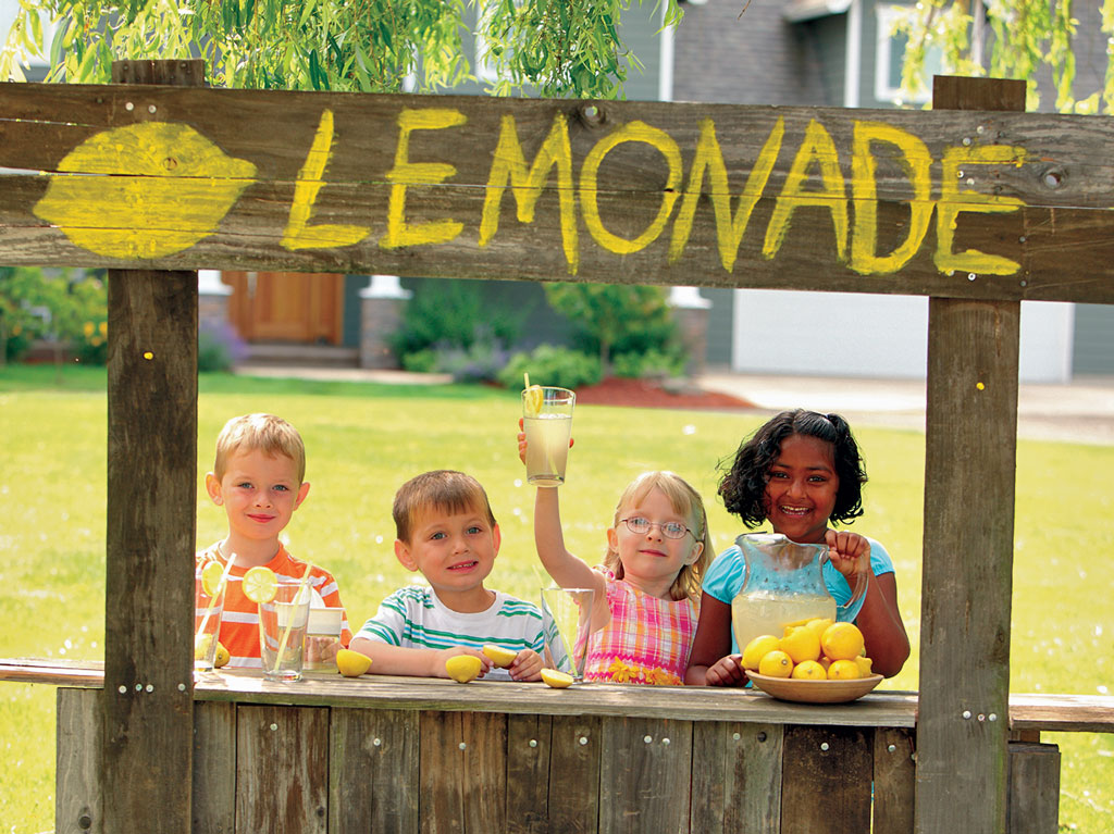 four kids selling lemonade