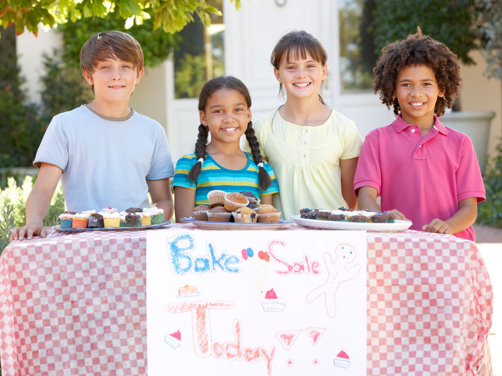 kids smiling at their bake sale table