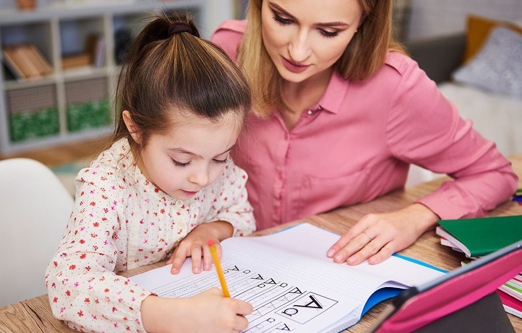 mom helping young girl with homework