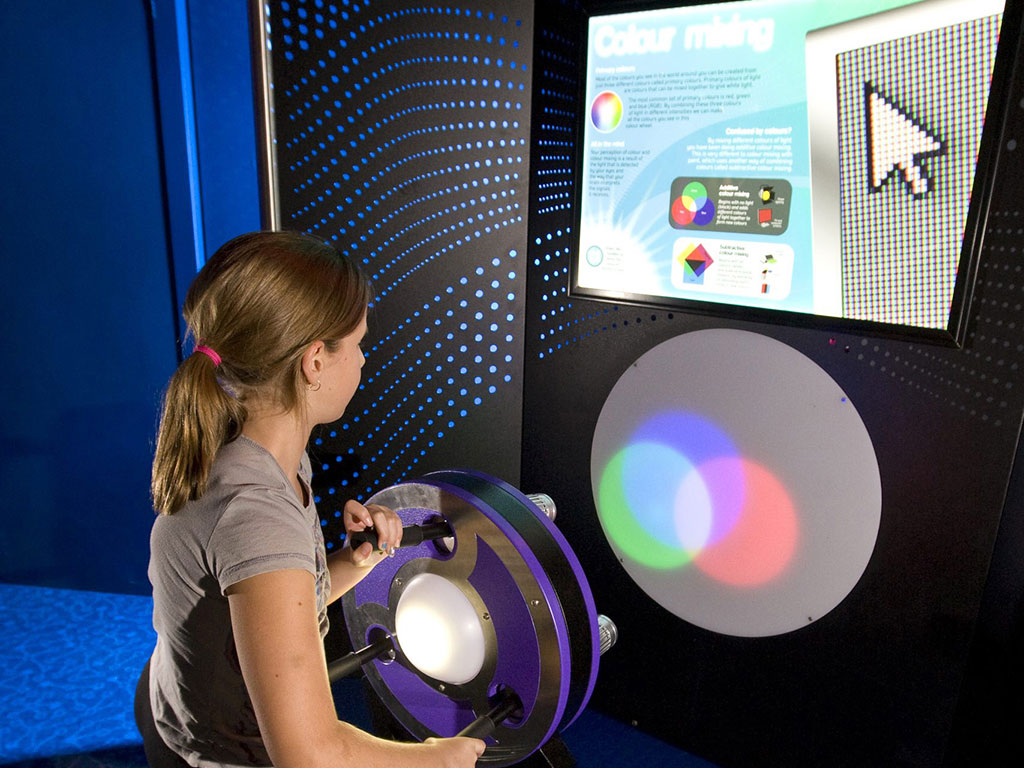 young girl learning about light through the "Playing With Light" interactive exhibit