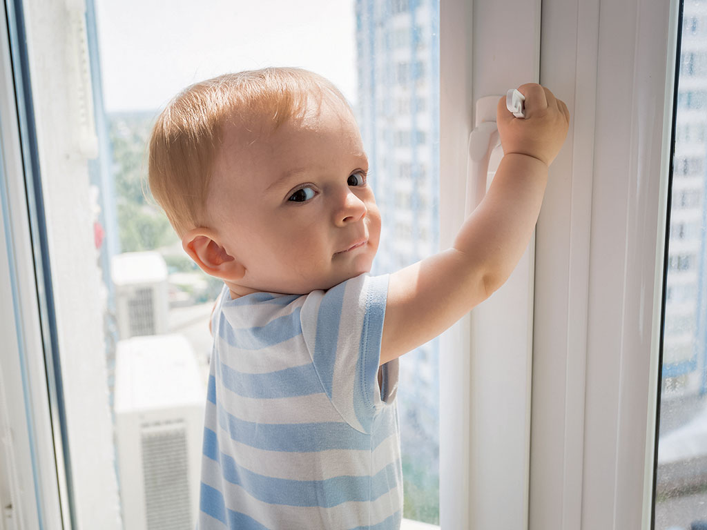 a toddler about to open a window