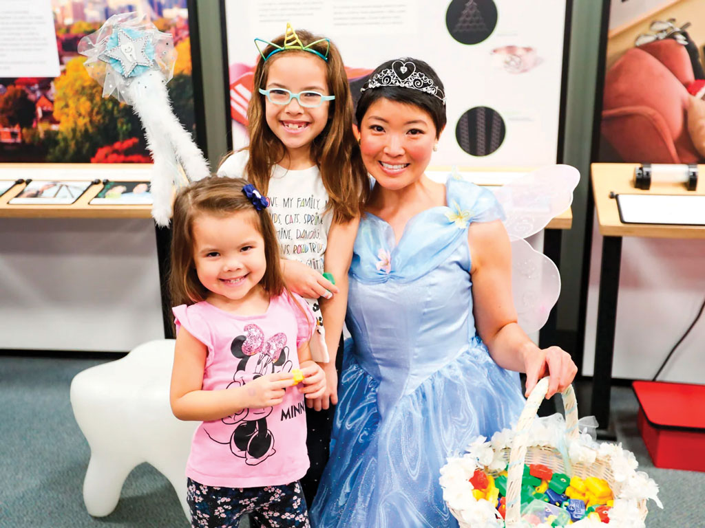 tooth fairy smiling with two young girls