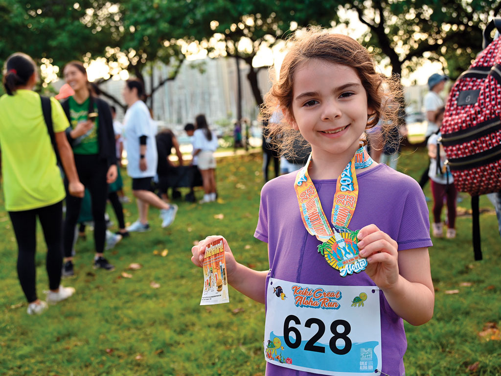 a happy child showing her medal after running a race