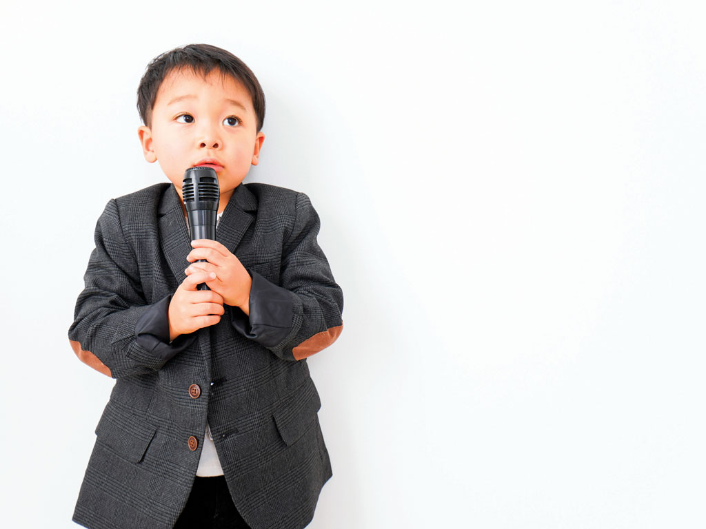 a shy young boy with a microphone
