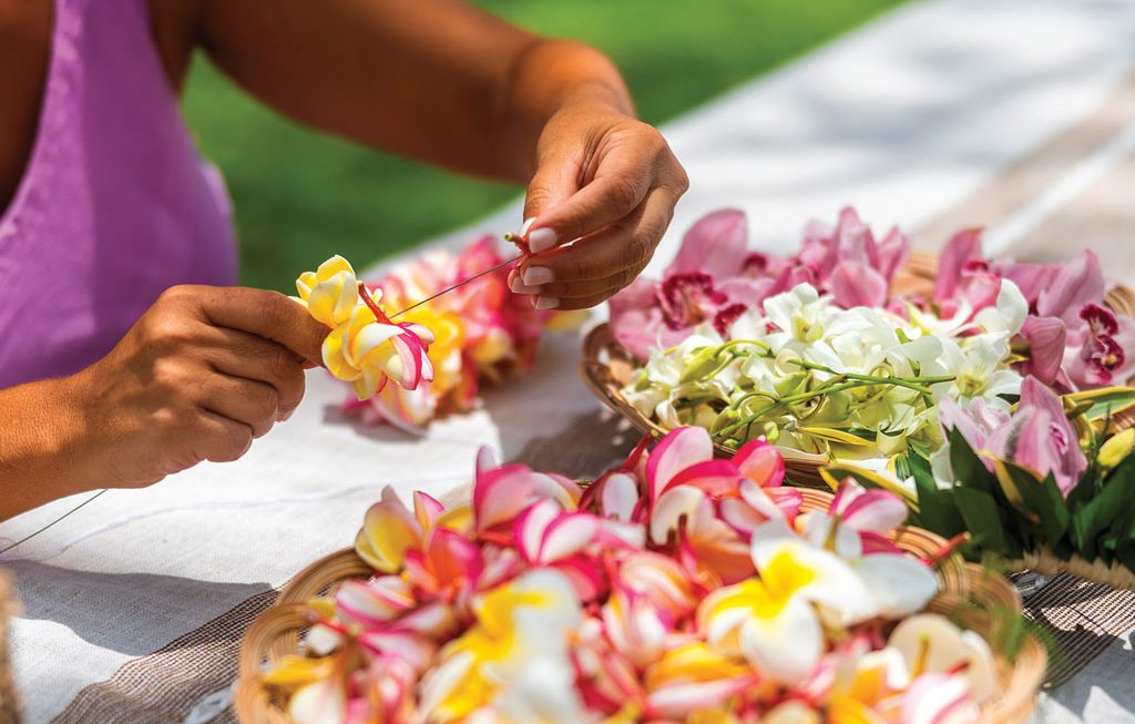 a woman putting together a lei