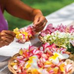 a woman putting together a lei