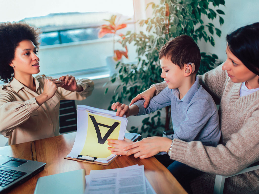 mother and son learning sign language with a professional