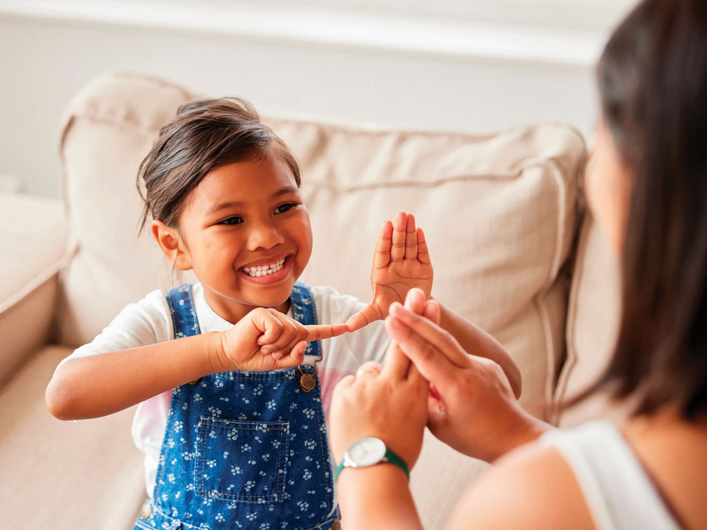 young girl signing with her mom
