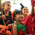 kids in Halloween costumes at the door waiting for candy