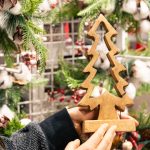 woman holding wooden christmas tree from craft fair