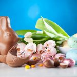 Pink Flowers Between Chocolate Rabbit Figure and Decorated Easter Eggs
