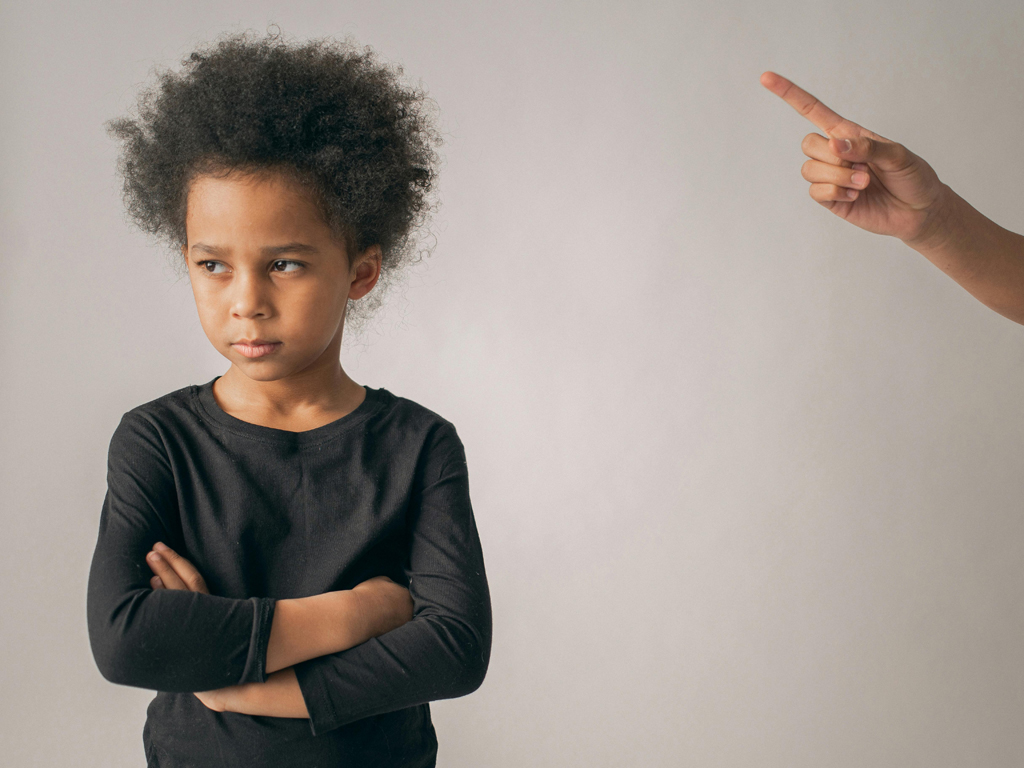 A child is upset as she's being scolded by parent