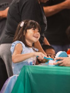 child learning to brush teeth on a model set of teeth