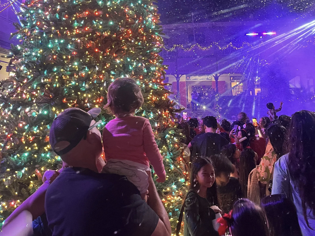 Families celebrating Christmas with a display and snow blizzard