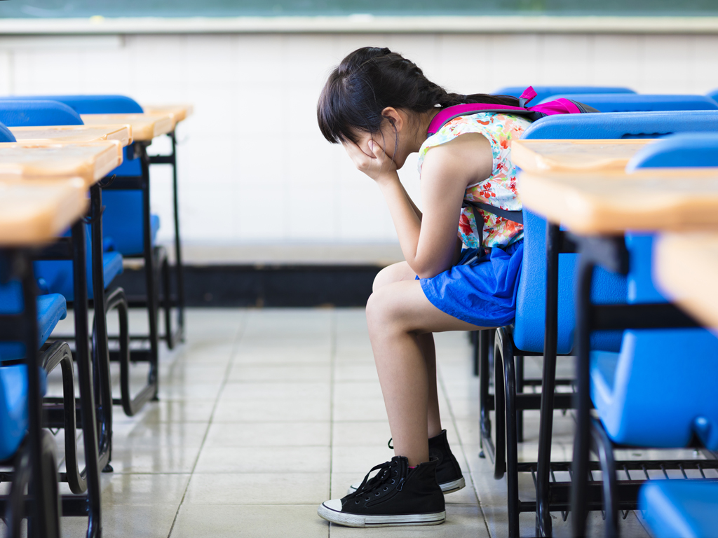 sad girl sitting and thinking in the classroom