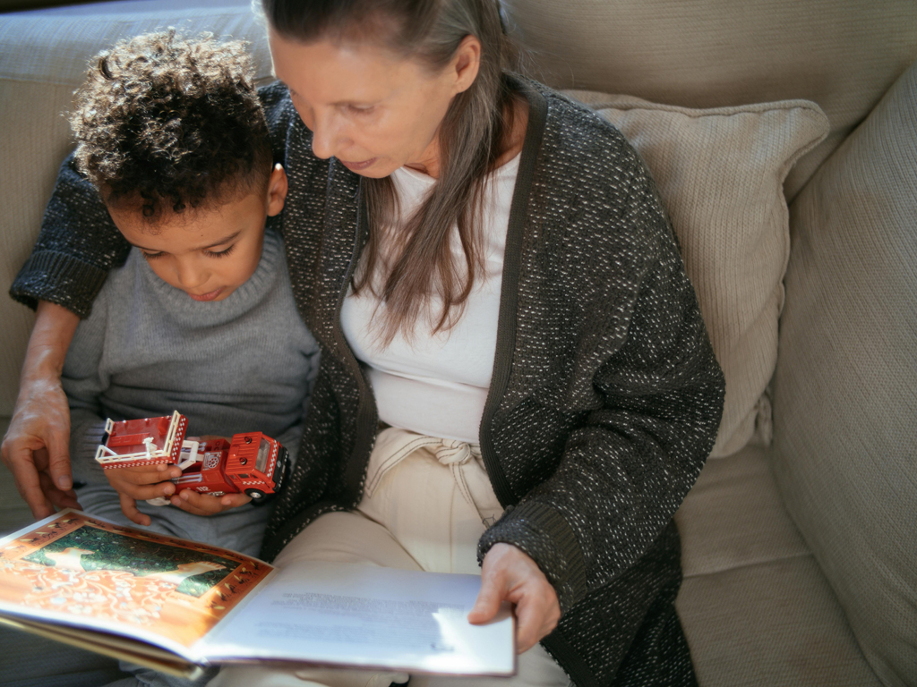 mom and son reading a book on the sofa