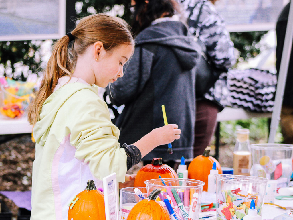 young girl painting a pumpkin