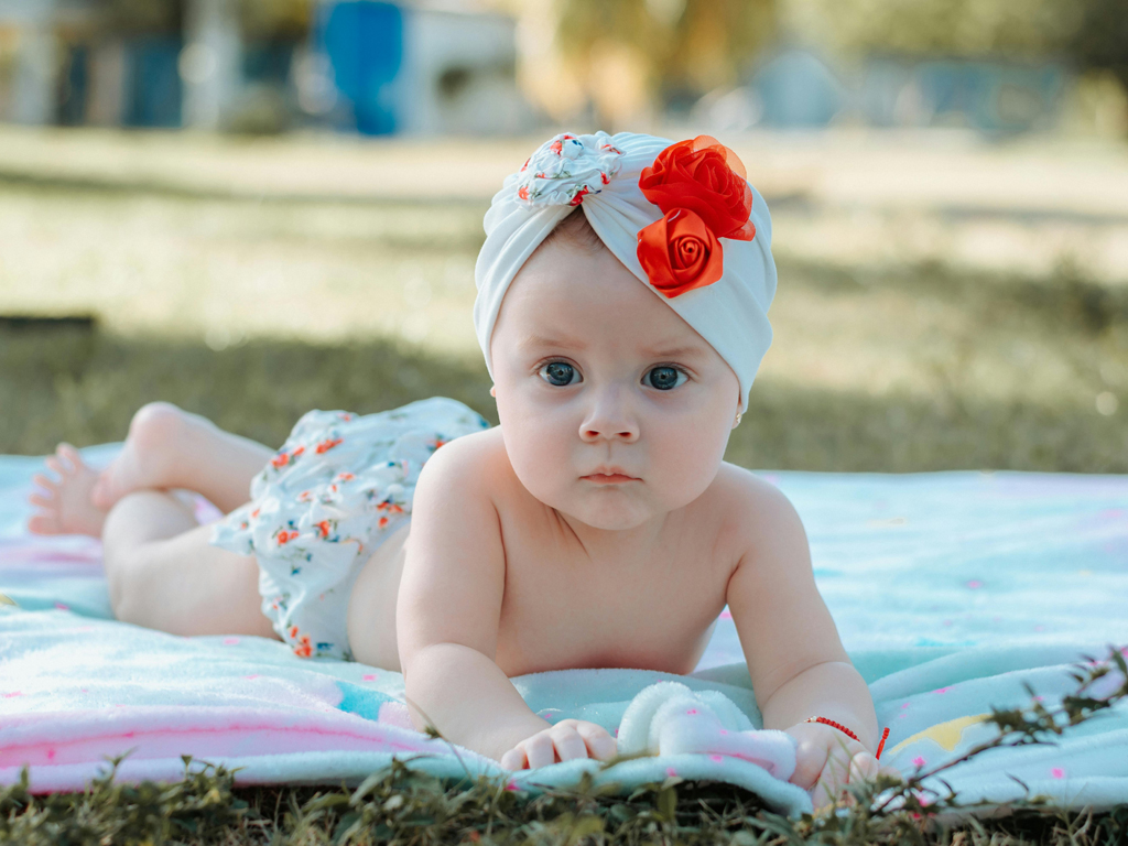 baby on their tummy on a picnic blanket