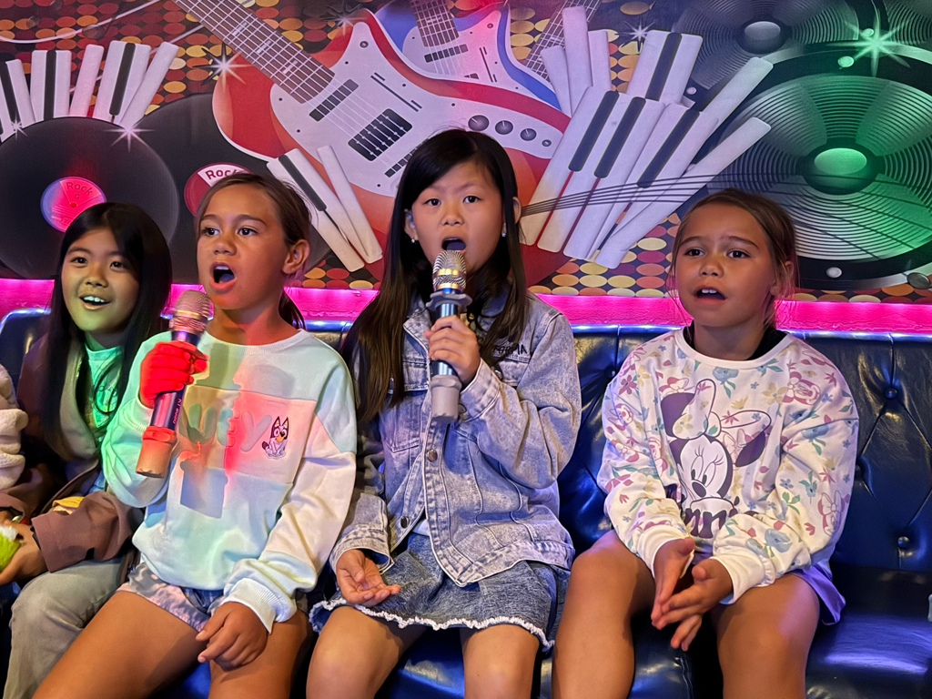 a group of four girls singing at karaoke