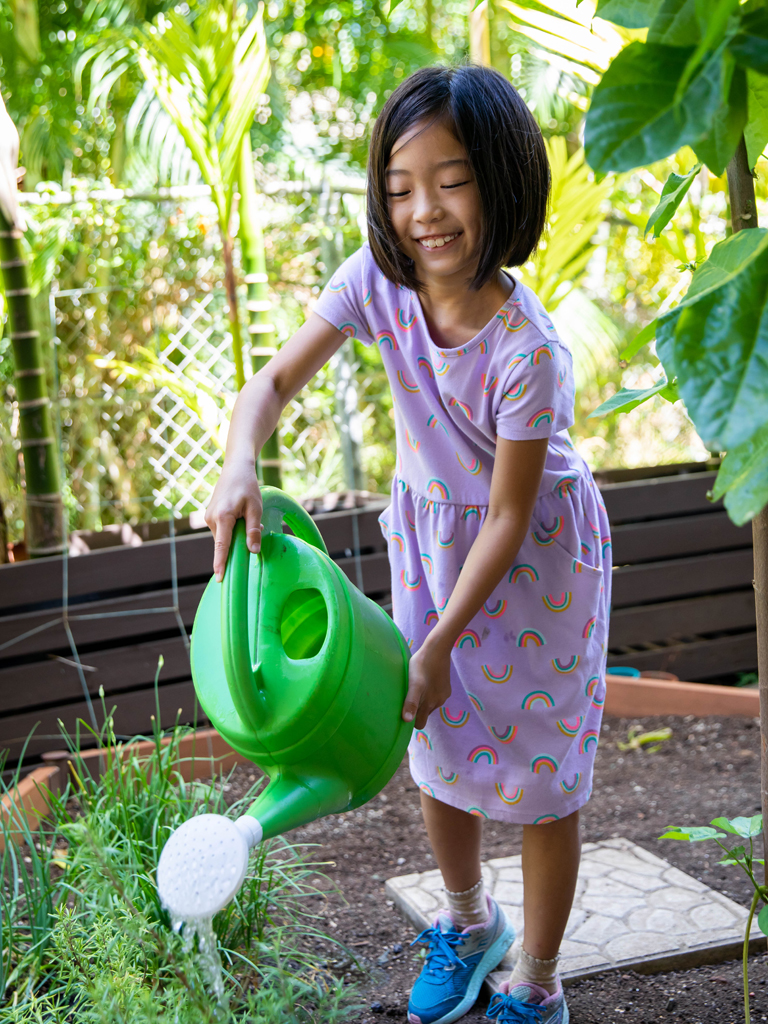 a young girl watering plants