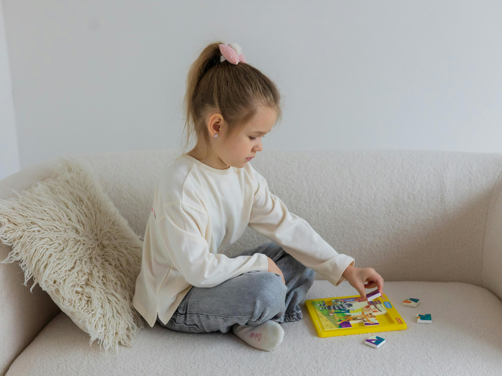 a young girl working on a puzzle