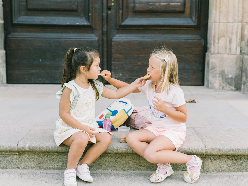 two girls sharing a snack