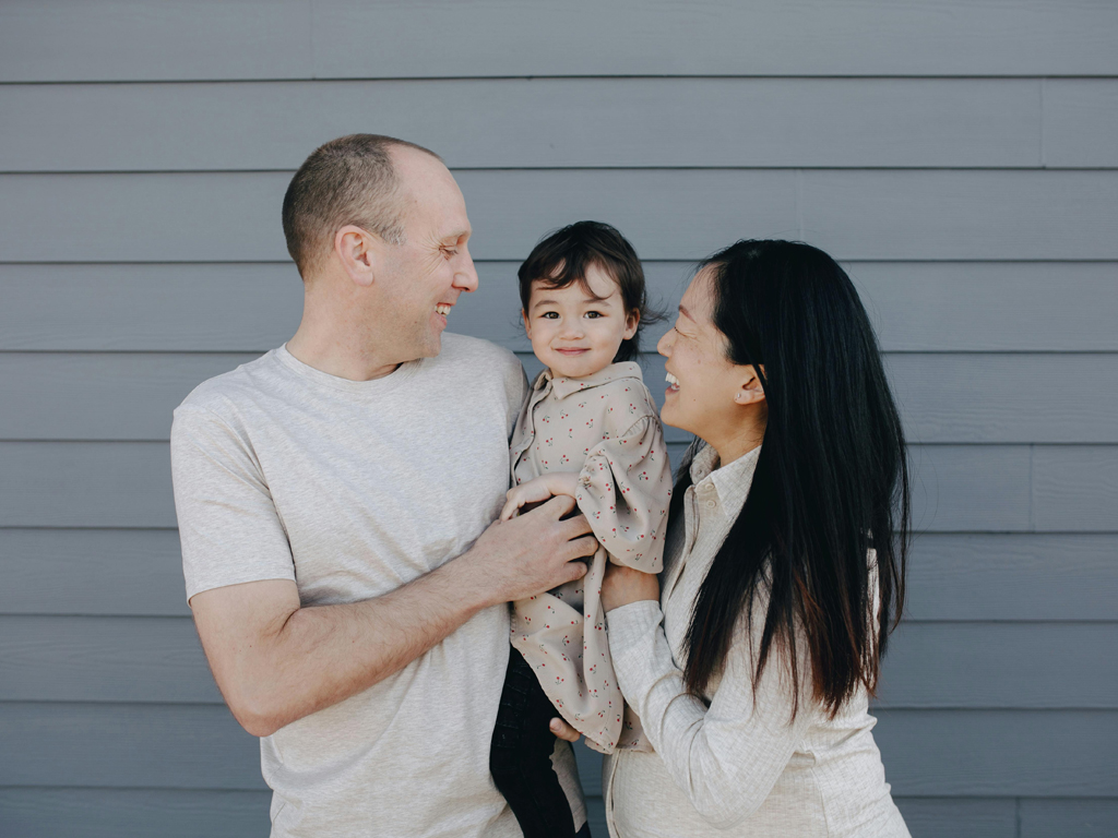 happy parents holding their toddler
