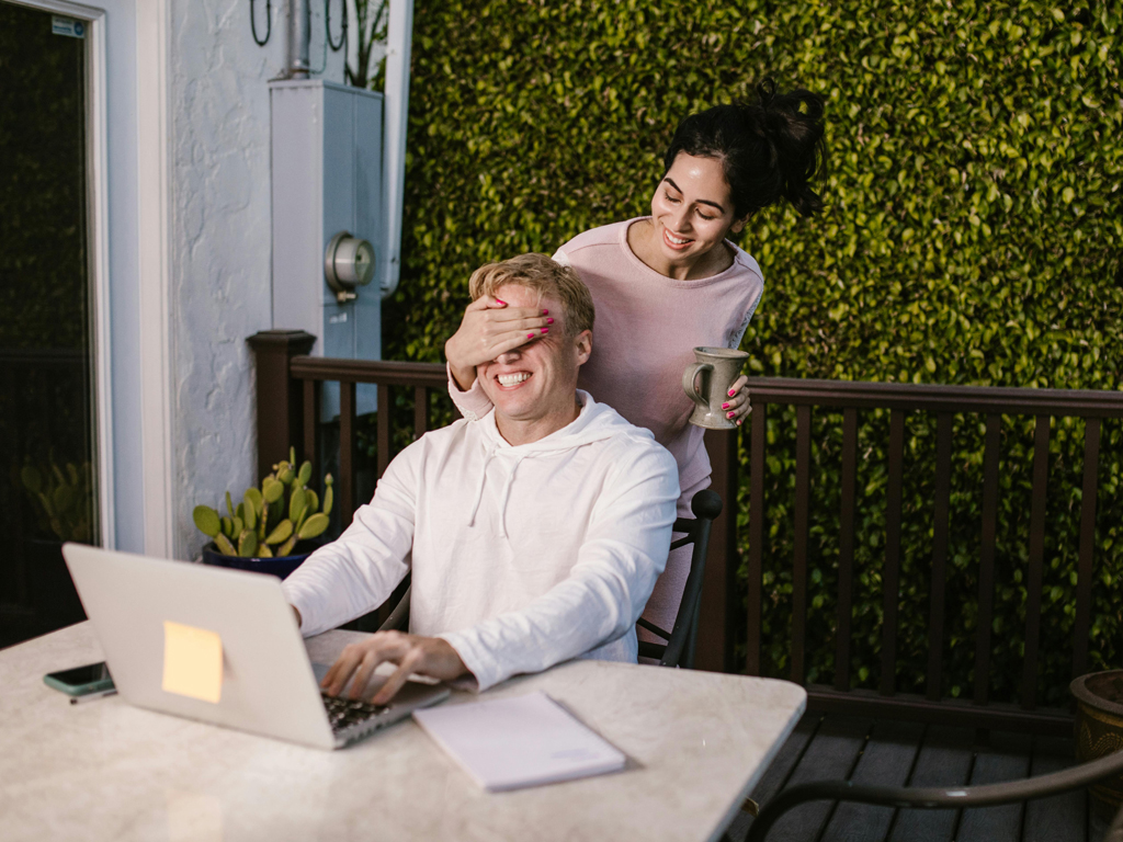 female playfully covering her partner's eyes