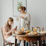 mom trying to talk to her teenage daughter who is on her smartphone