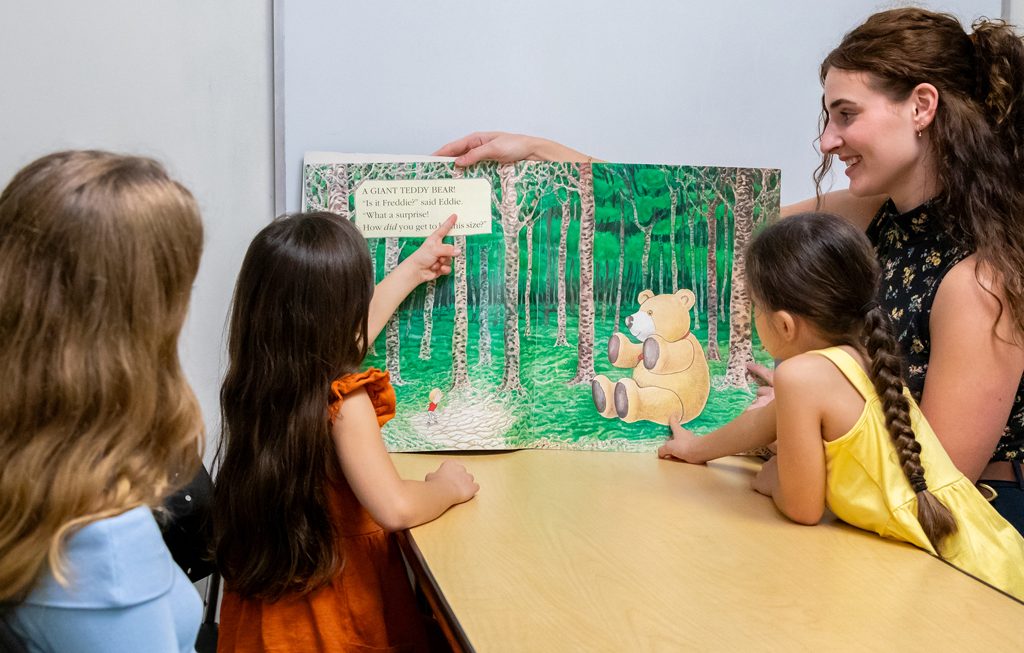 teacher reading a book to children