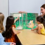 teacher reading a book to children
