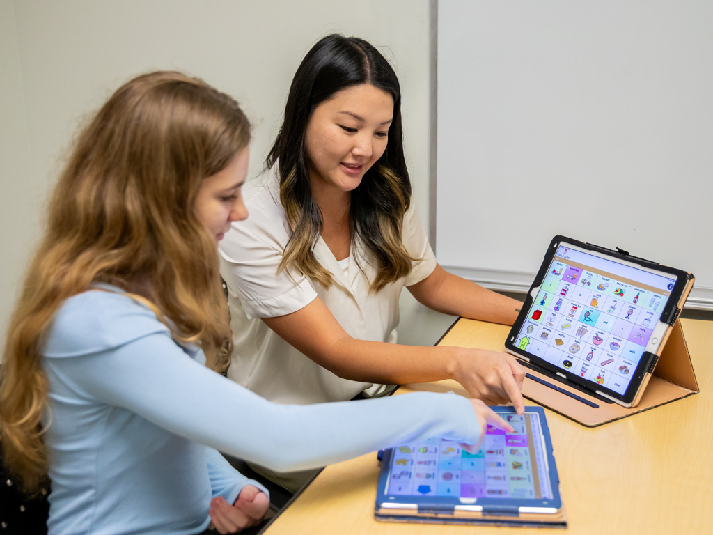 teacher teaching a student on an tablet device
