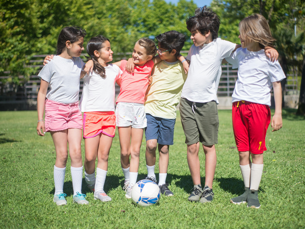 six young soccer players with arms around each other