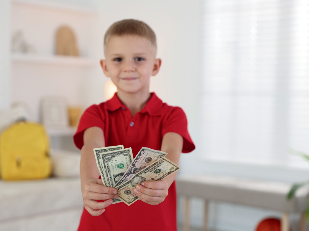 child presenting a handful of cash