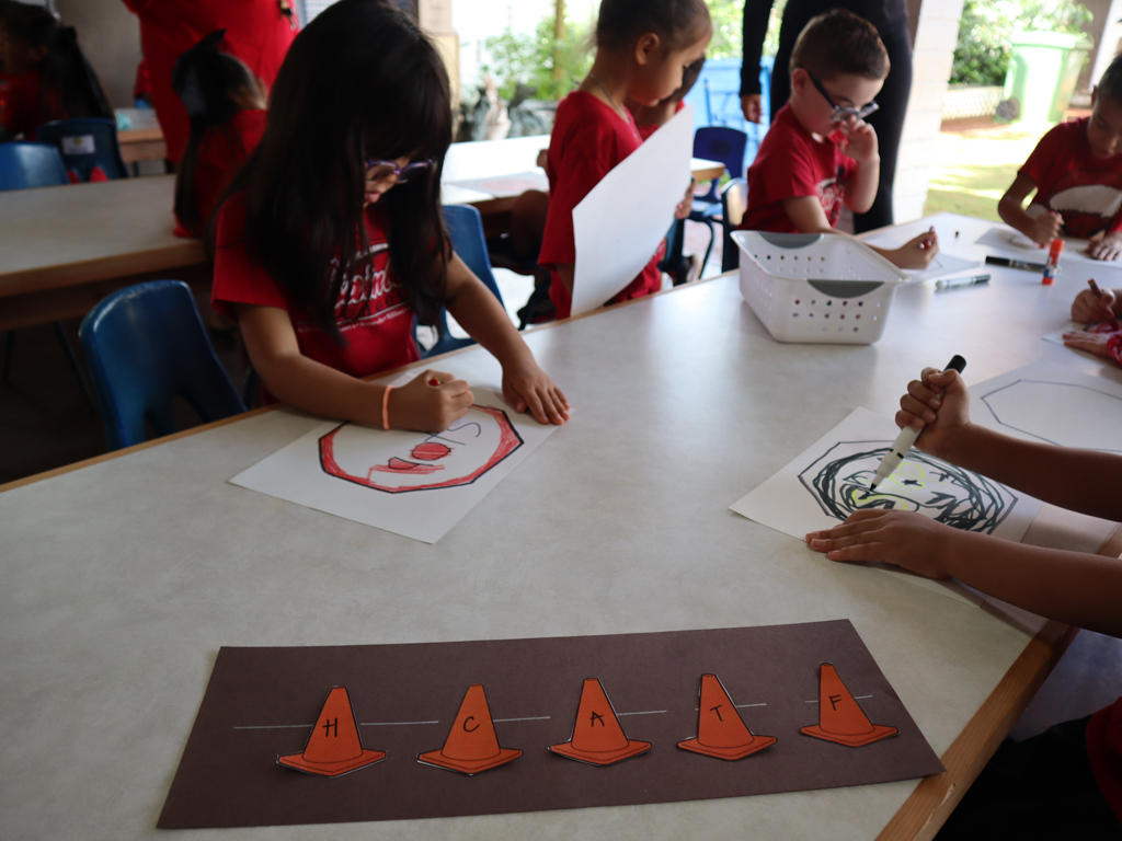 Rainbow Schools students coloring on donated tables
