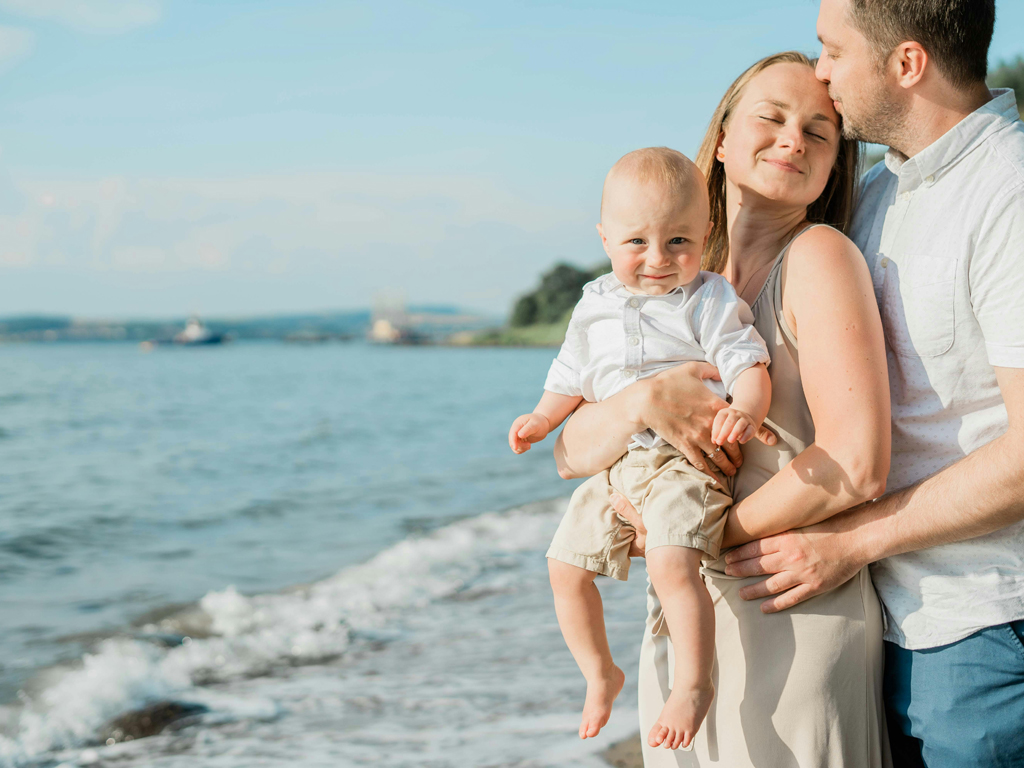 parents affectionately holding their toddler